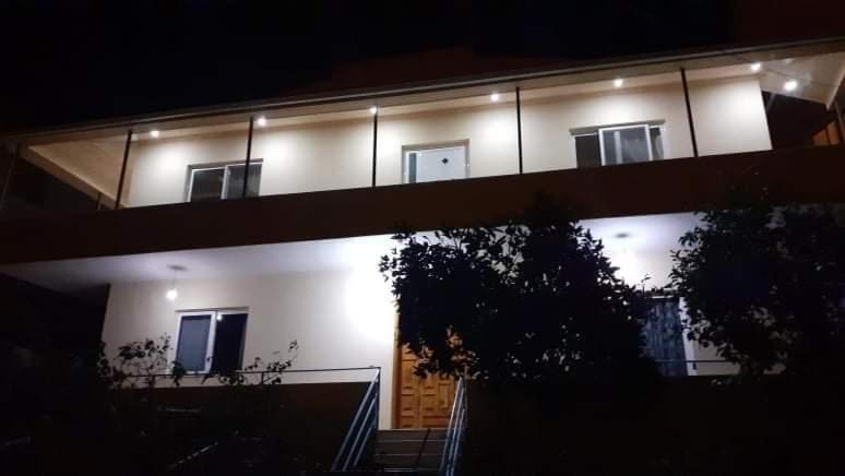 a house with lights on the side of it at night at STEFAN VASILI in Sarandë