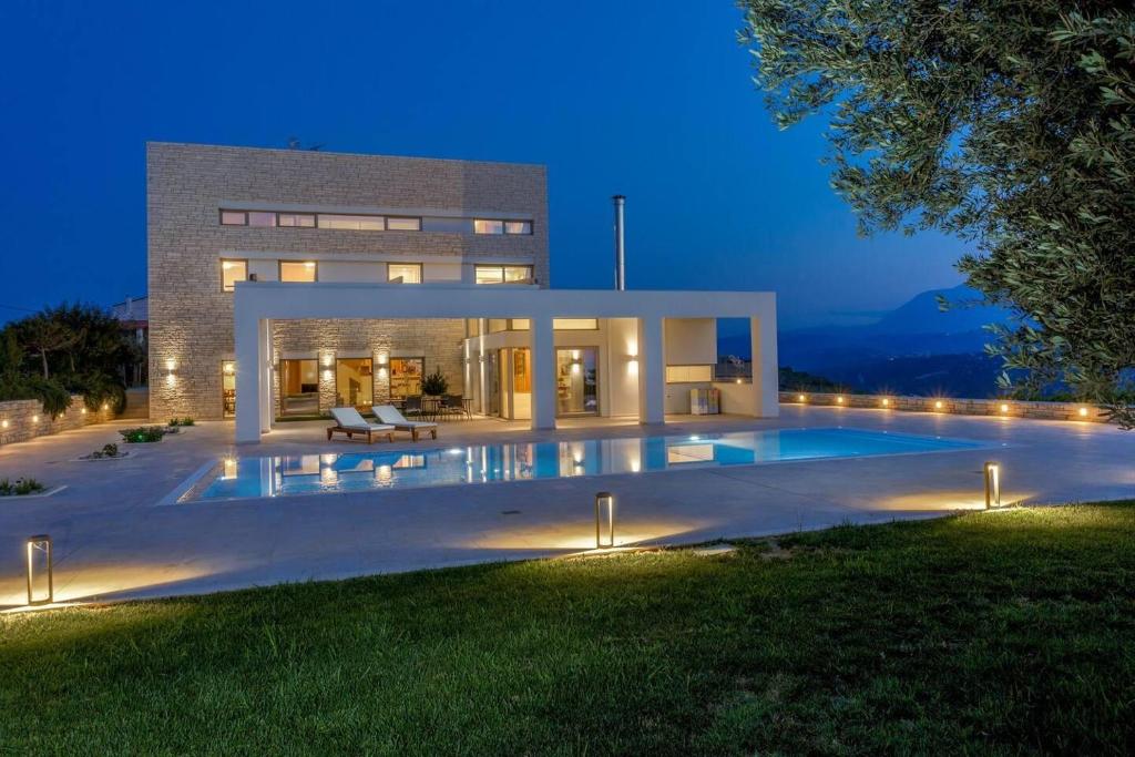 a large house with a swimming pool at night at Luxurious 6- Bed Private Villa in Heraklion Crete in Athánatoi