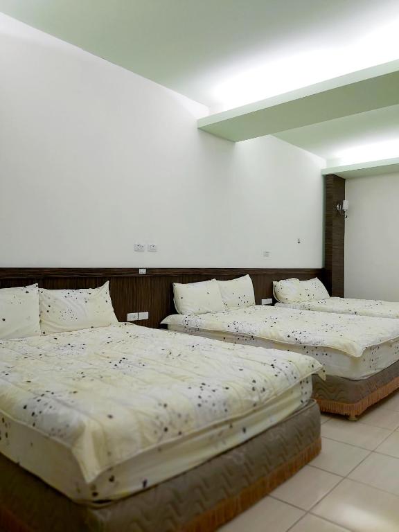 three beds are lined up in a room at Happy Heart B&amp;B in Taitung City