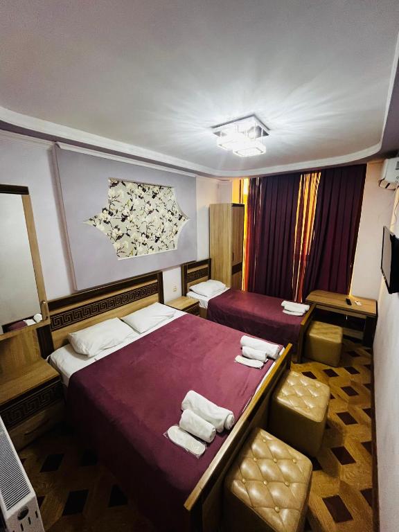 a hotel room with two beds and a chair at Georgian Palace Hotel in Kutaisi