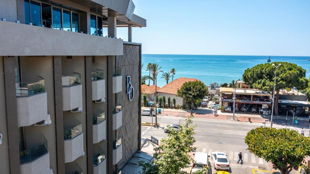 een uitzicht op een straat met een gebouw en de oceaan bij Büyük Hotel in Alanya