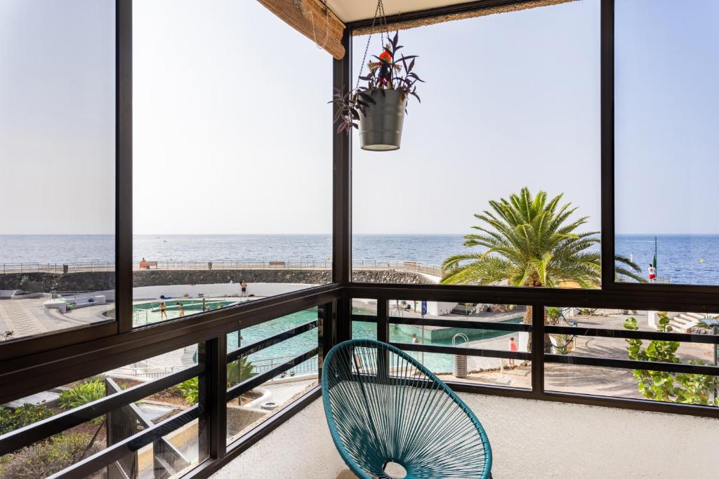 een stoel op een balkon met uitzicht op het strand bij EDEN RENTALS Pure Oasis Ocean Views in El Rosario