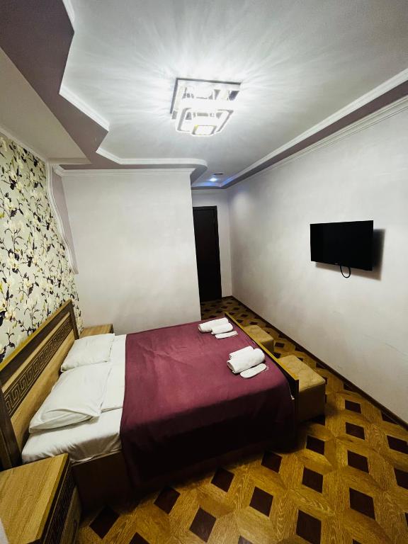 a bedroom with a bed and a flat screen tv at Georgian Palace Hotel in Kutaisi