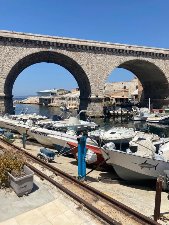 a group of boats docked in a harbor under a bridge at Le Cabanon du Vallon des Auffes in Marseille