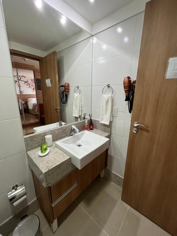 a bathroom with a sink and a mirror at Vista da Pedra Flat in Pedra Azul