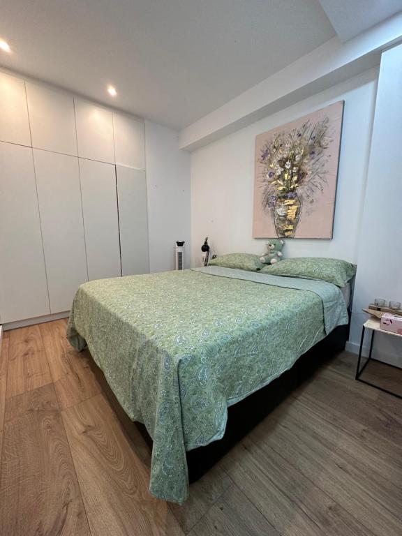 - une chambre avec un grand lit et une couverture verte dans l'établissement Apartment near by downtown beach, à Barcelone