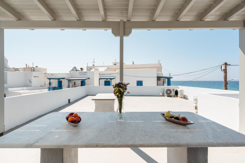 uma mesa com um vaso de frutas numa varanda em Celestial Seaview Apartments- Ariadne em Naxos Chora