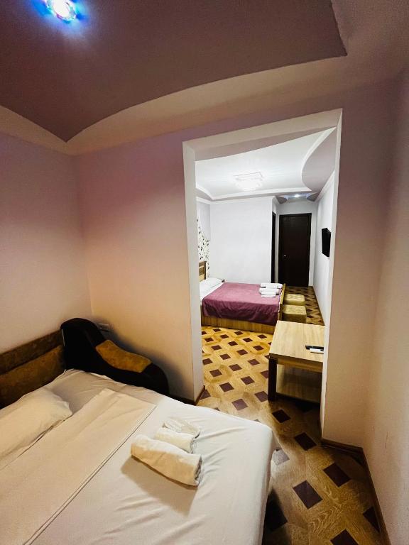 a bedroom with a bed and a room with a table at Georgian Palace Hotel in Kutaisi