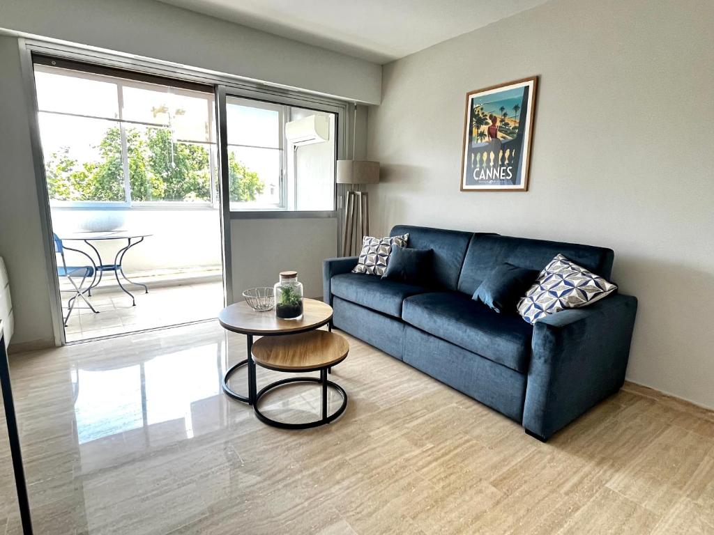 un salon avec un canapé bleu et une table dans l'établissement La douceur de vivre à Cannes, à Cannes