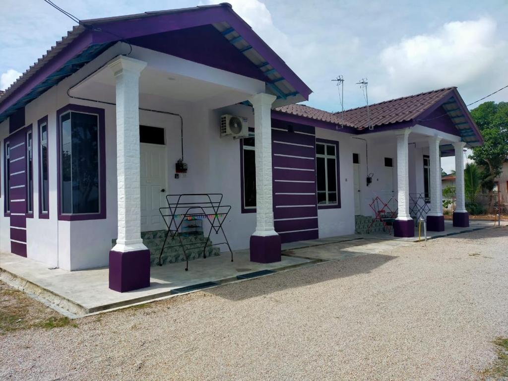 une petite maison avec un toit violet dans l'établissement WK HOMESTAY PASIR MAS, à Pasir Mas