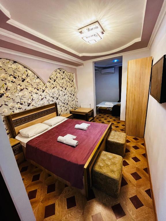 a bedroom with a bed with two towels on it at Georgian Palace Hotel in Kutaisi