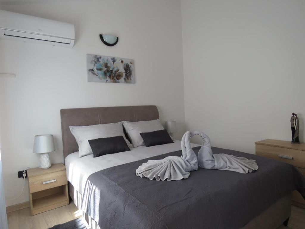 a bedroom with a bed with a swan decoration on it at Erika Medulin in Medulin