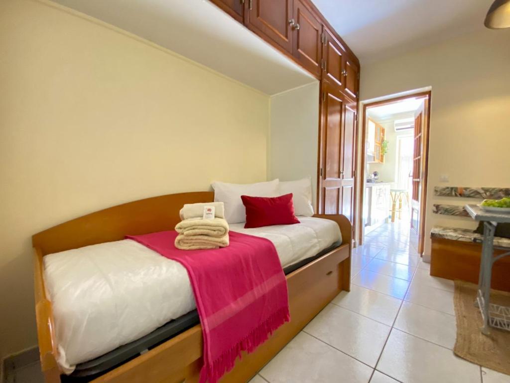 1 dormitorio con 1 cama con manta rosa en Faro Airport Flat 7 by Homing en Faro