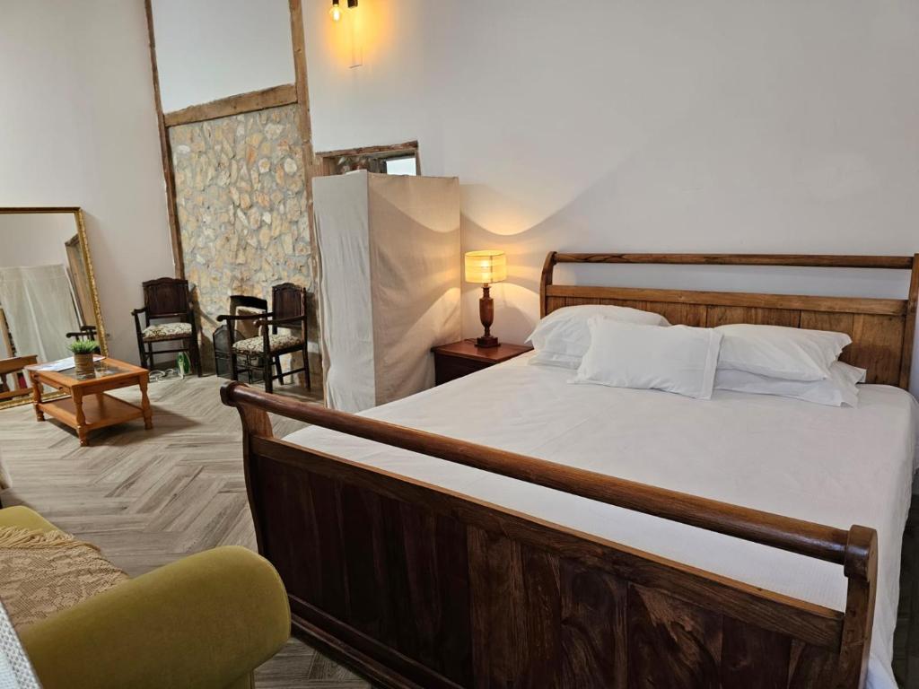 a bedroom with a large bed and a chair at Casa das Flores - no Parque Natural Guadiana in Mértola