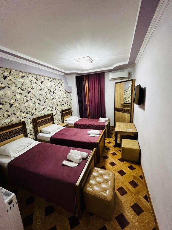 a hotel room with two beds and a chair at Georgian Palace Hotel in Kutaisi