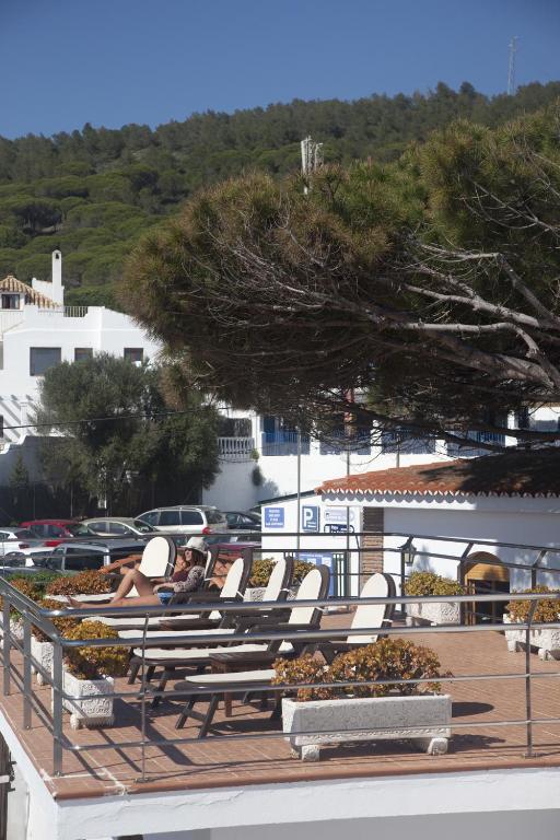 a group of lawn chairs sitting on a deck at Hostal Mar de Frente in Los Caños de Meca
