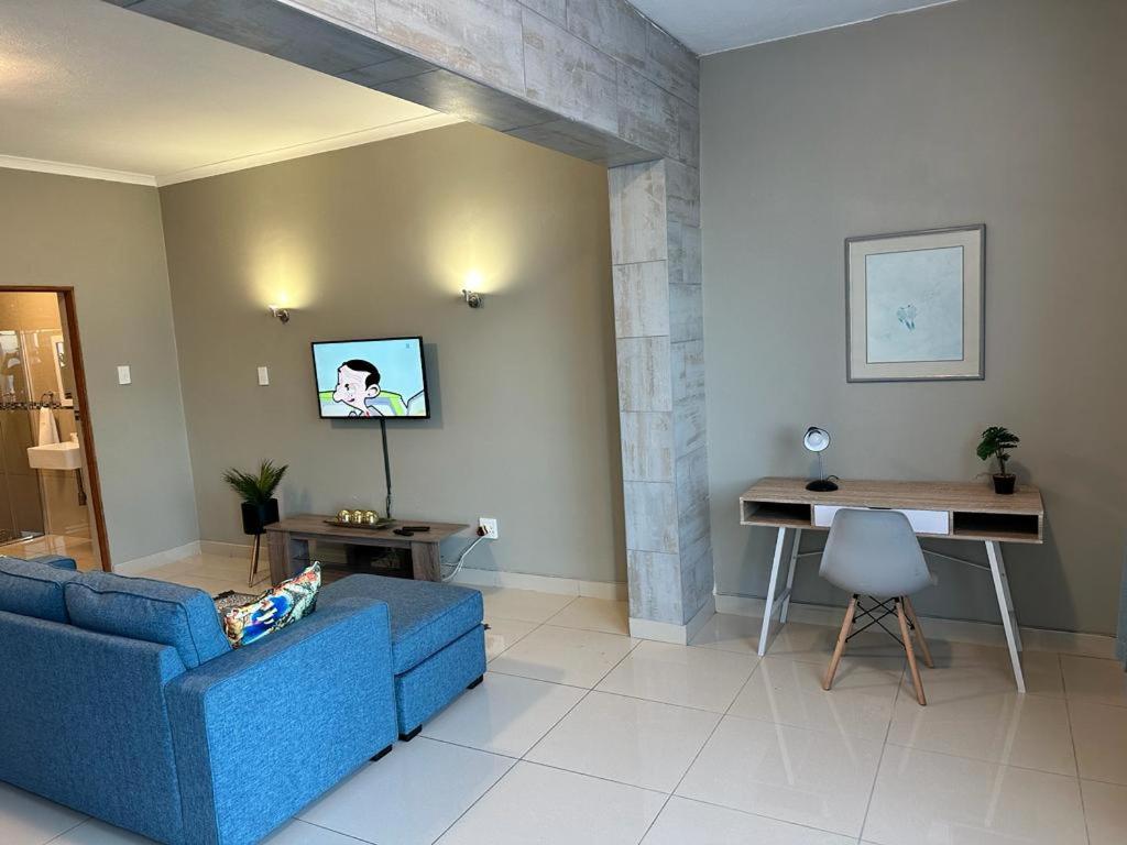 a living room with a blue couch and a desk at St Ives beach access apartment in Margate