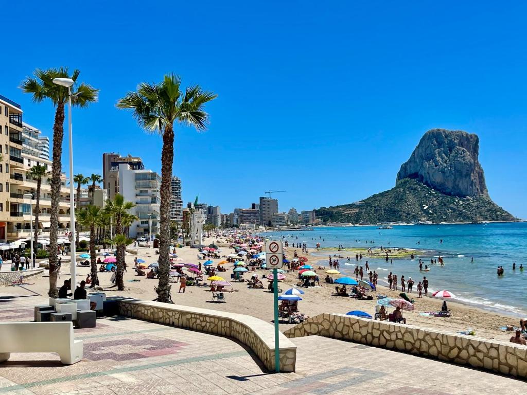 a beach with a crowd of people and the ocean at Pasión Junto al mar in Calpe