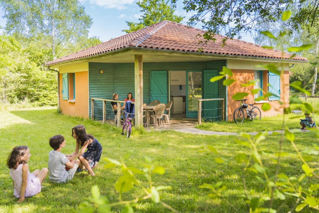 eine Gruppe von Kindern, die auf dem Gras vor einem Haus sitzen in der Unterkunft Gîtes De La Barbotine in Le Fuilet
