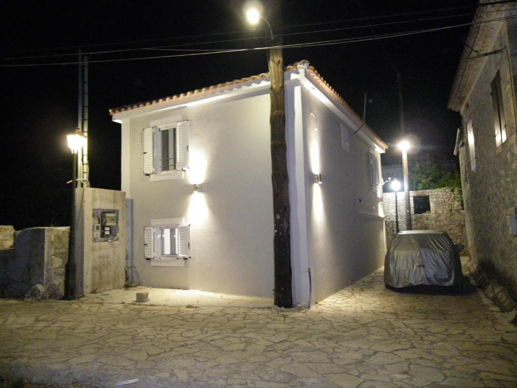 a white building with a door at night at Vikou House in Yírion