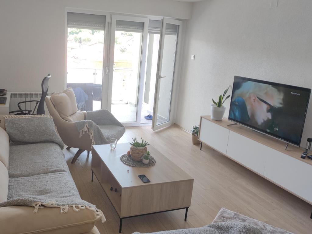 un soggiorno con una grande TV a schermo piatto di Cozy apartment with mountain view 