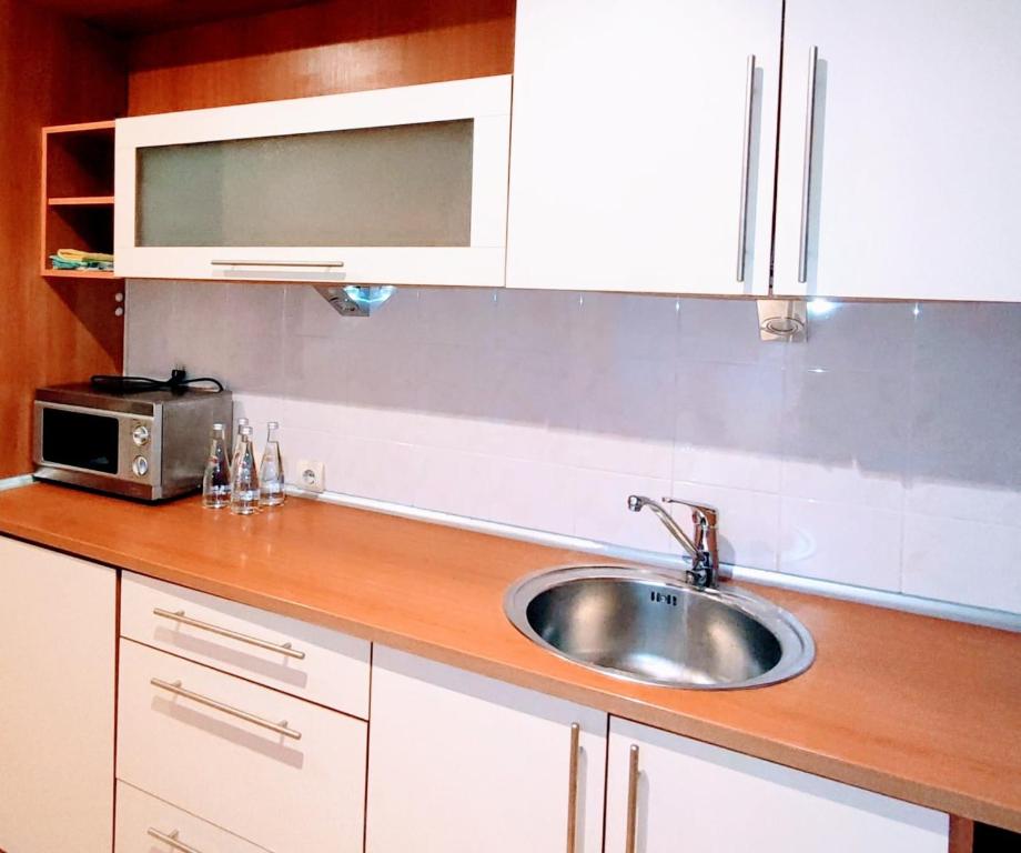 a kitchen counter with a sink and a microwave at Perfect flat city centre in Sigulda