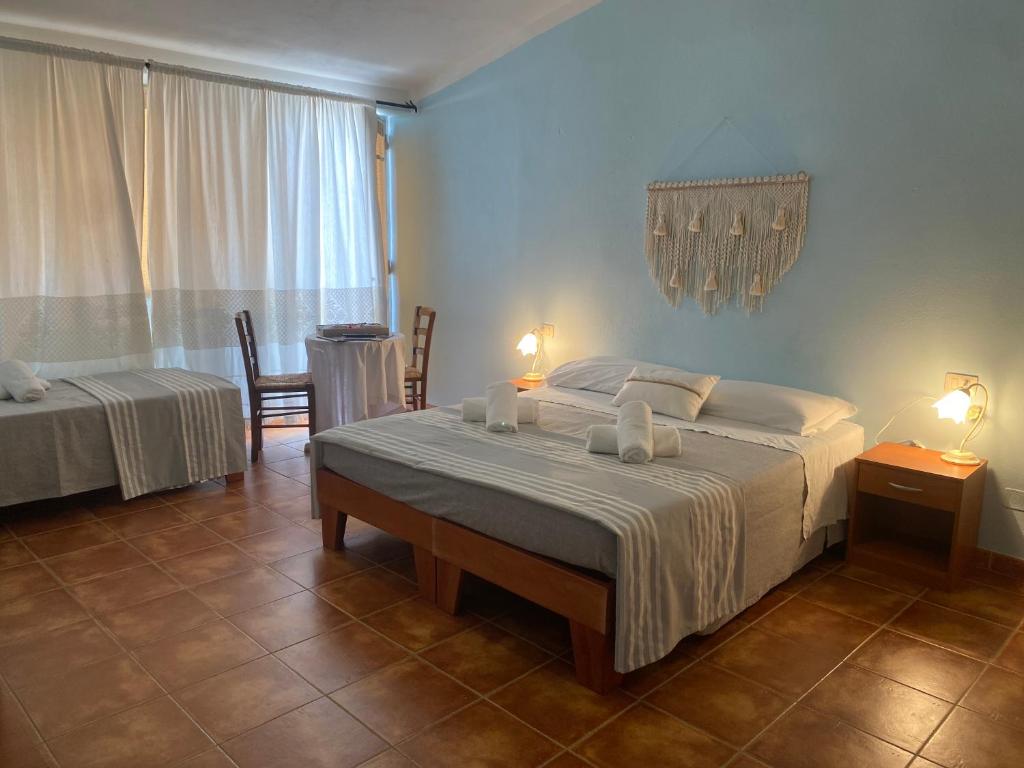 - une chambre avec 2 lits, une table et des chaises dans l'établissement B&B La Pitraia, à Sant Antonio Di Gallura