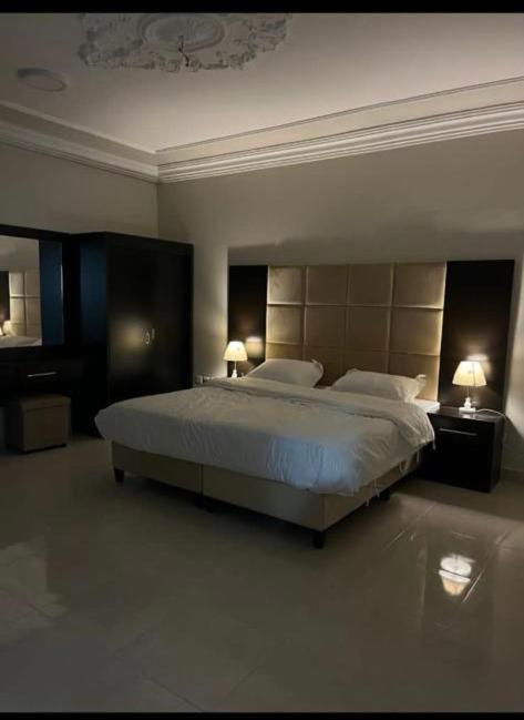 ein großes Schlafzimmer mit einem großen Bett und zwei Lampen in der Unterkunft شقق بدور أرضي in Medina