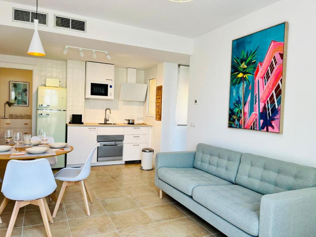 a living room with a blue couch and a kitchen at Lancón Boutique- Precioso apartamento a 150 m a pie de playa Lancón- Carboneras in Carboneras