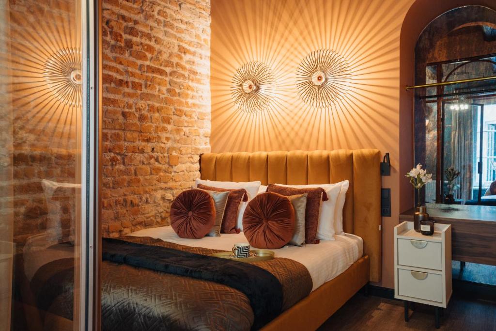ein Schlafzimmer mit einem Bett und einer Ziegelwand in der Unterkunft Cu Residence - LoftAffair Collection in Krakau