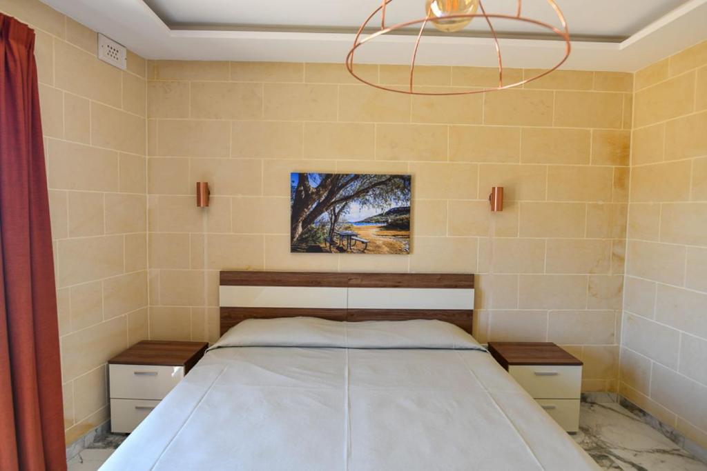 a bedroom with a bed and a chandelier at Azure W B&B in San Lawrenz