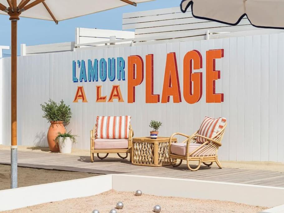 レイヨル・カナデル・シュル・メールにあるSuperbe, rénové, au calme, plage 200m, terrasse vue Mer!の大きな看板の前に椅子2脚とテーブル