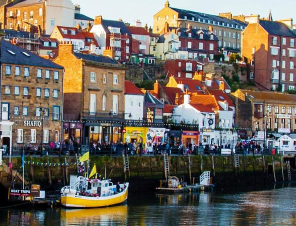 una ciudad con barcos en el agua y edificios en Hilltop House, en Whitby
