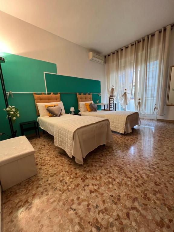 a bedroom with two beds and a green wall at VERONA CENTRO MARIA's HOUSE in Verona