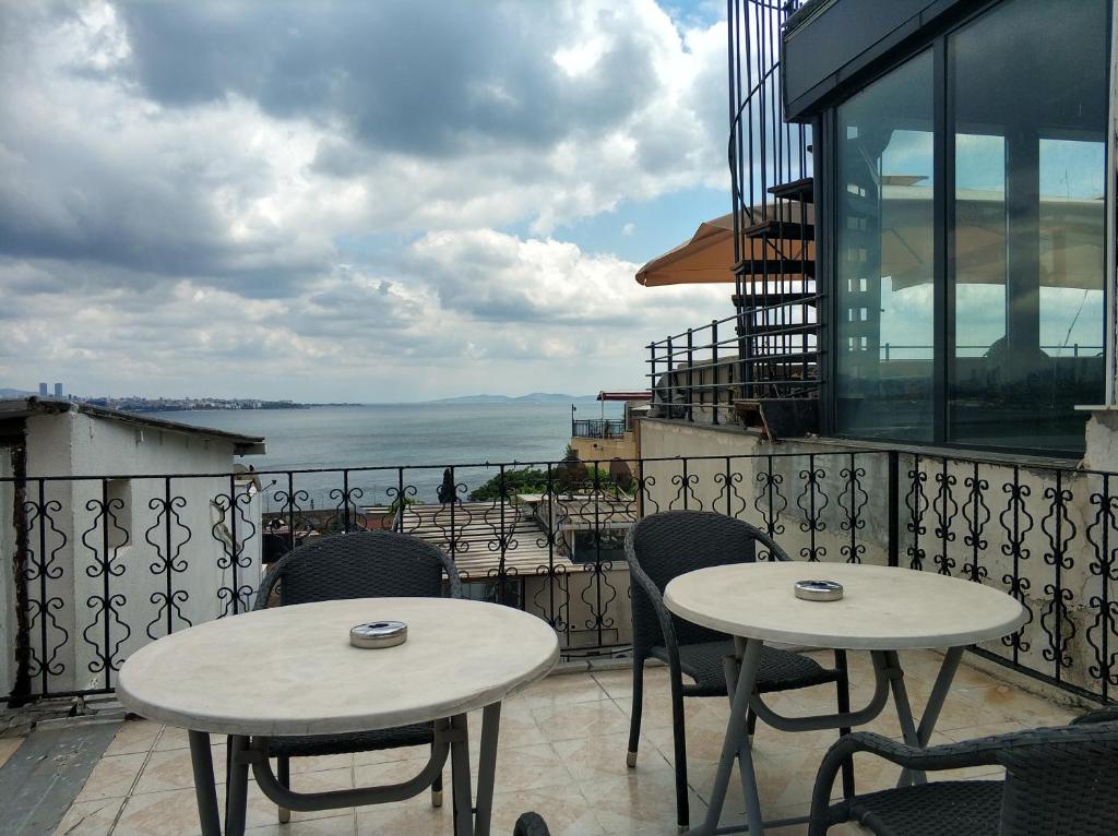 two tables and chairs on a balcony with a view of the ocean at Gul Sultan Hotel in Istanbul