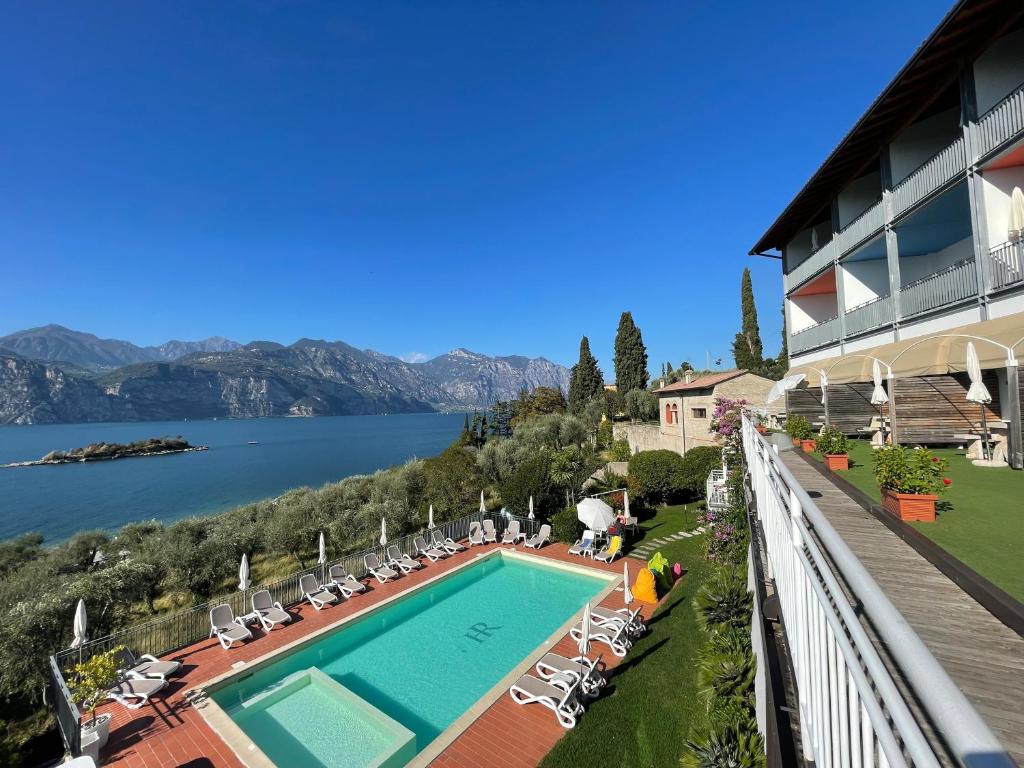 een resort met een zwembad en uitzicht op een meer bij Hotel Roma Aparthotel in Malcesine