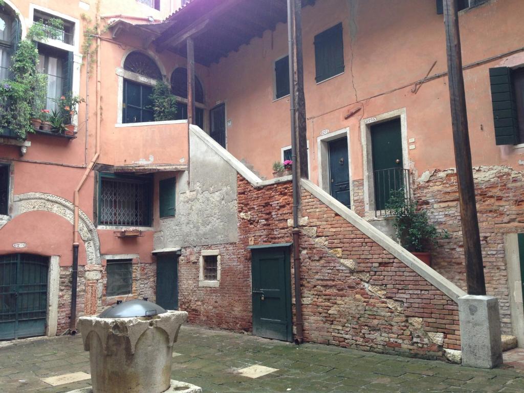 un edificio de ladrillo con una escalera y un edificio con un cubo de basura en Ca' Botera, en Venecia