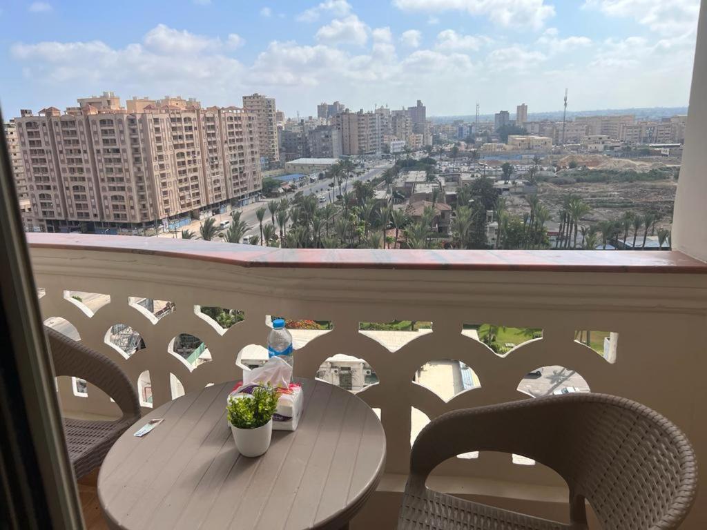 a table on a balcony with a view of a city at شقة فاخرة في كمبوند ميامى جراند بلازا الإسكندرية in Alexandria