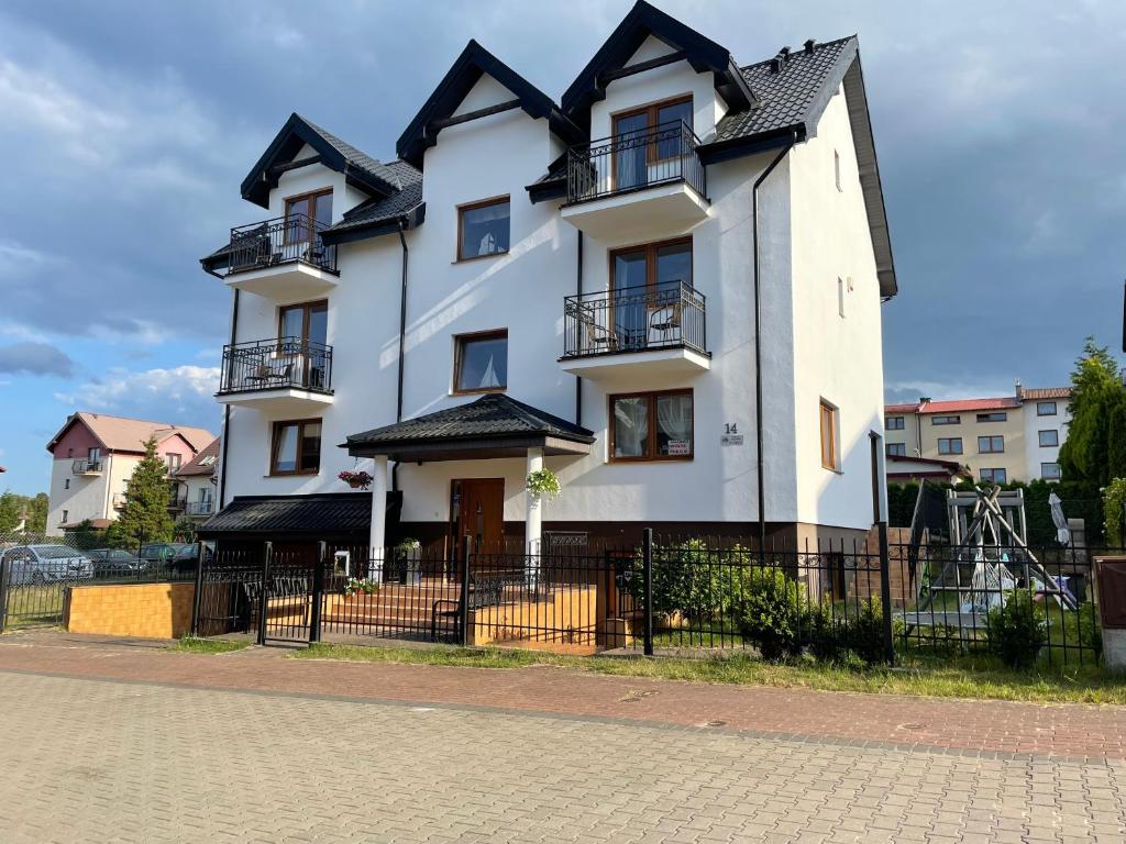 a large white house with a black roof at Willa Filip in Władysławowo