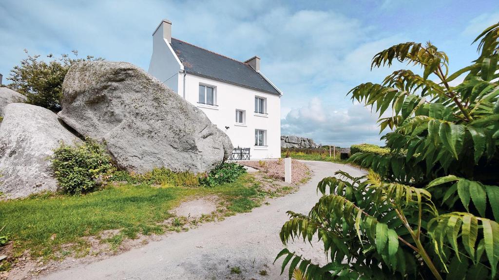 Kerlouan的住宿－Ty Meham, à 700m de la plage et Meneham, grand terrain calme，前面有一块大石头的白色房子