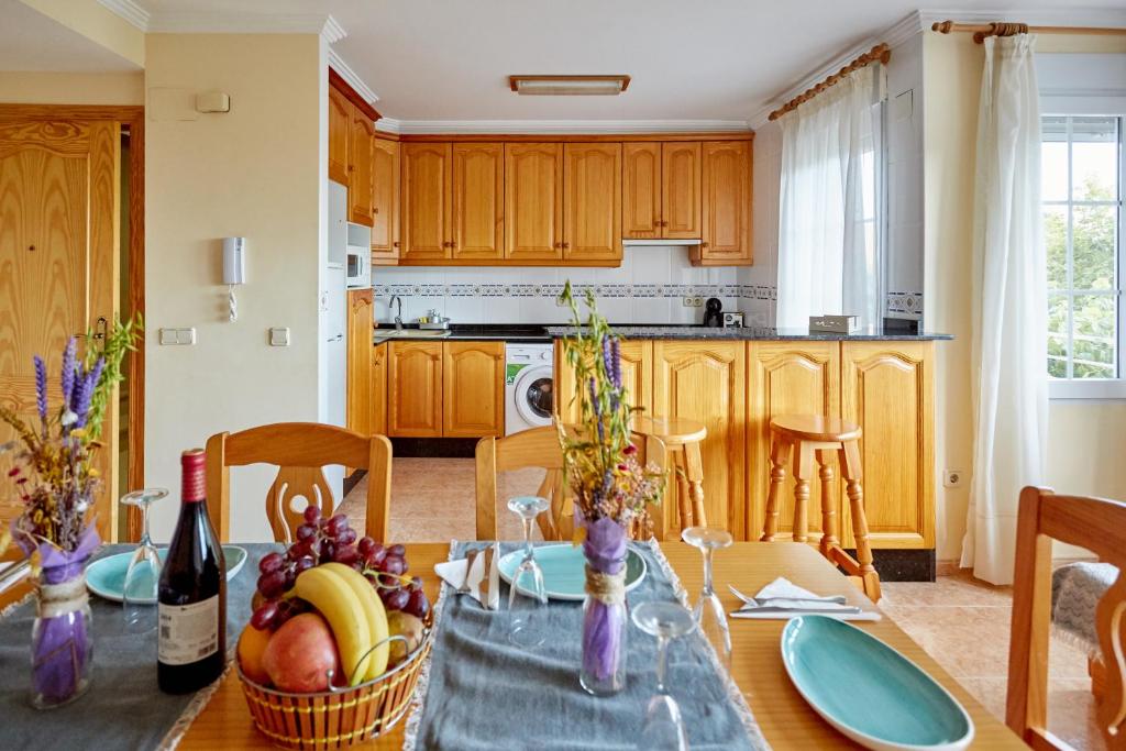 una cocina con una mesa con botellas de fruta y vino en Apartamentos Lorelay 1, en Peñíscola