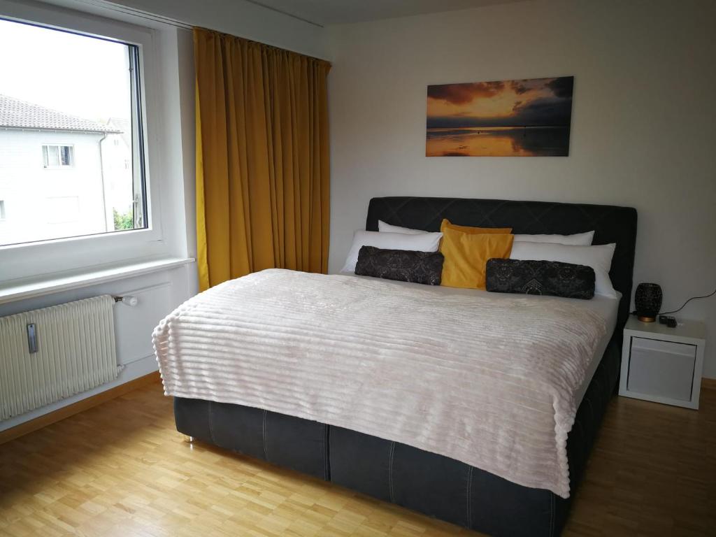 1 dormitorio con 1 cama grande y ventana grande en goldenes 1-Zimmer-Appartement Kreuzlingen, en Kreuzlingen