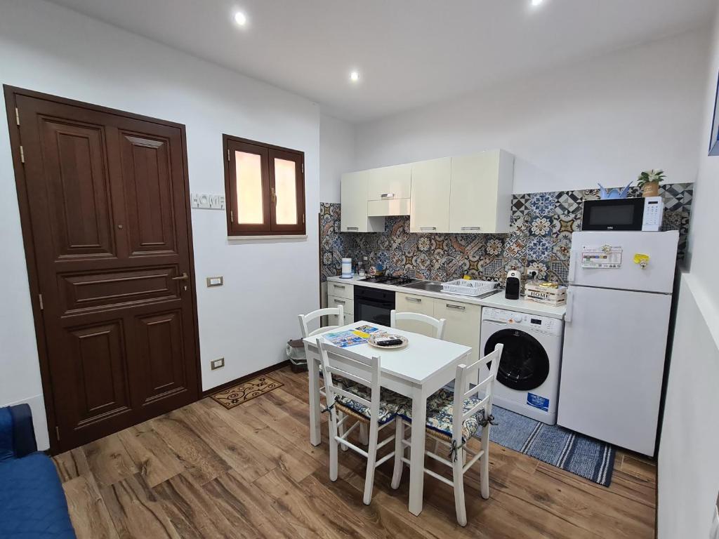 a small kitchen with a table and a refrigerator at La Maiolica Blu in Trapani