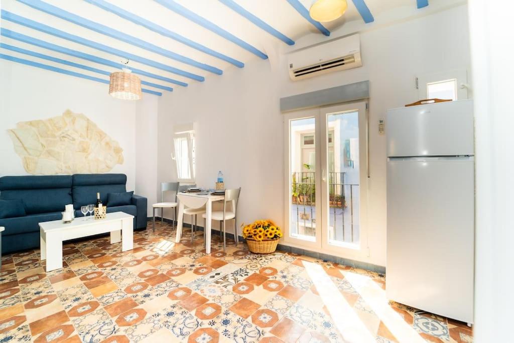 een woonkamer met een blauwe bank en een koelkast bij Alhambra Dreams 1958 in Villajoyosa