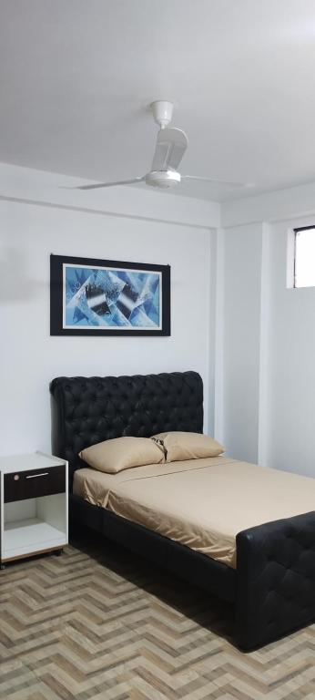 a bedroom with a bed with a black headboard at Makasai Tambopata 3 in Puerto Maldonado