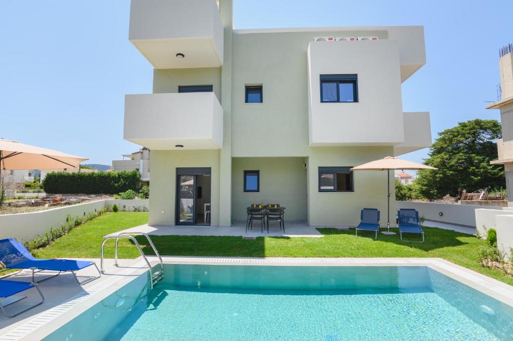 a villa with a swimming pool and a house at Green Villa in Ialyssos