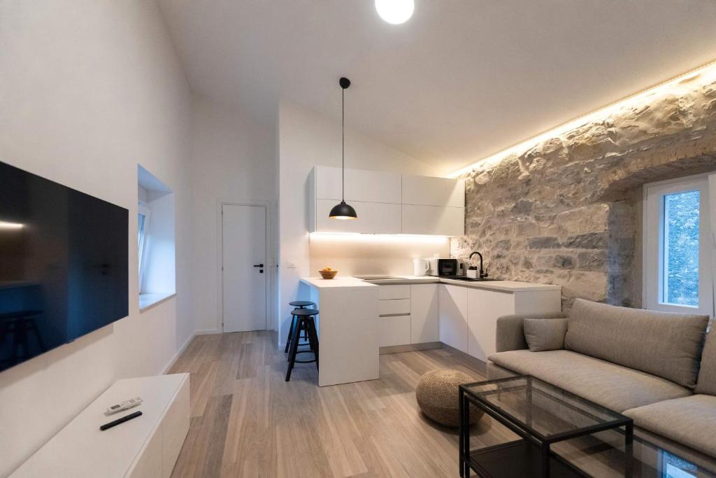 uma sala de estar com um sofá e uma cozinha em Lapidea apartments em Skradin
