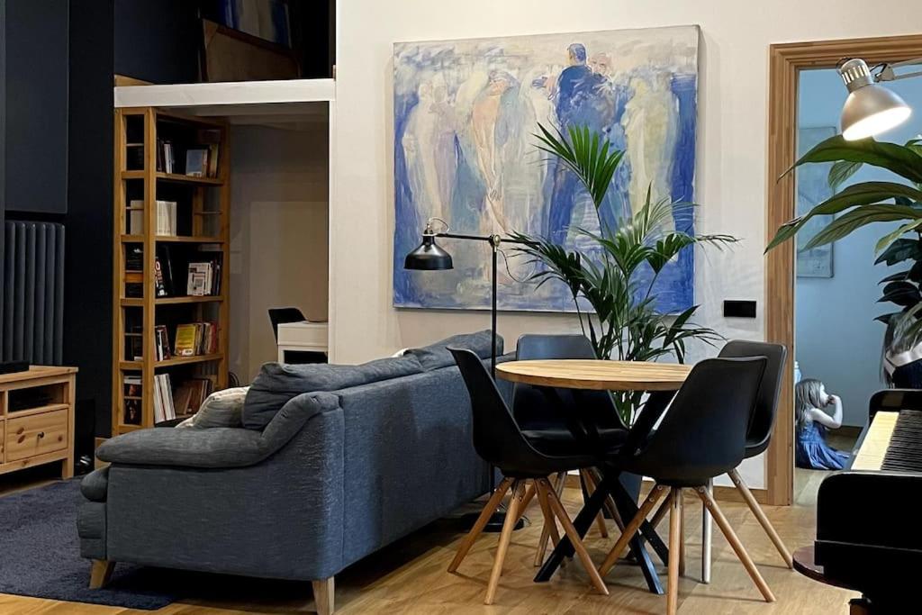 - un salon avec un canapé bleu et une table dans l'établissement The Artist Residence / 1 bedroom w/ Piano next to a Park, à Riga