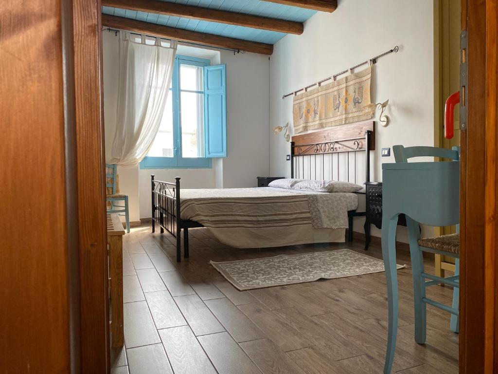 a bedroom with a bed and a table and a window at B&B Alba Chiara in Oristano