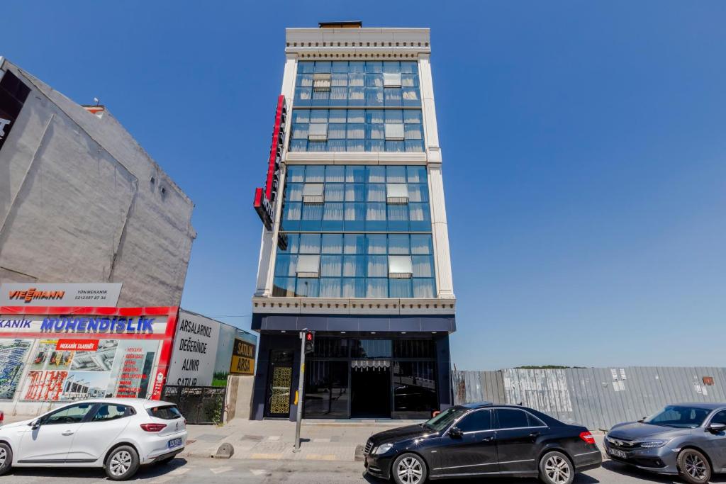 a tall building with cars parked in front of it at ACAR SMART OTEL in Arnavutköy